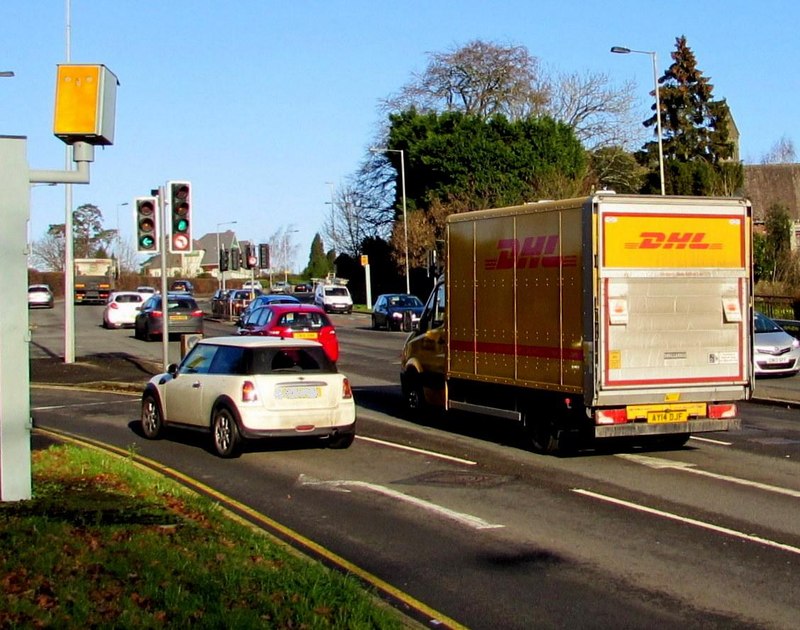 A red and yellow DHL delivery van on a street in Newport